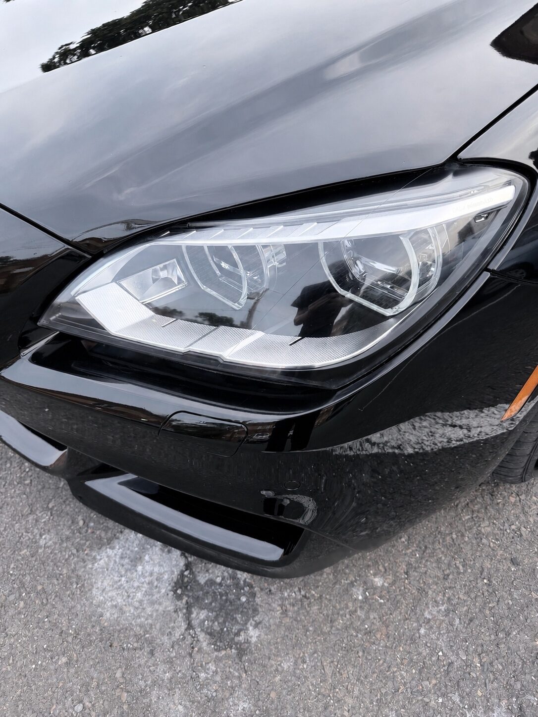 Glossy restored headlight on a black vehicle