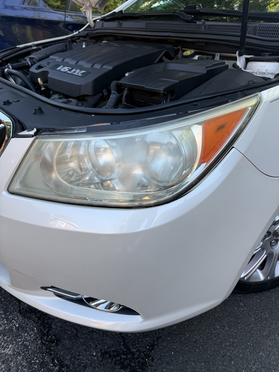 Cloudy headlight on a white sedan before restoration